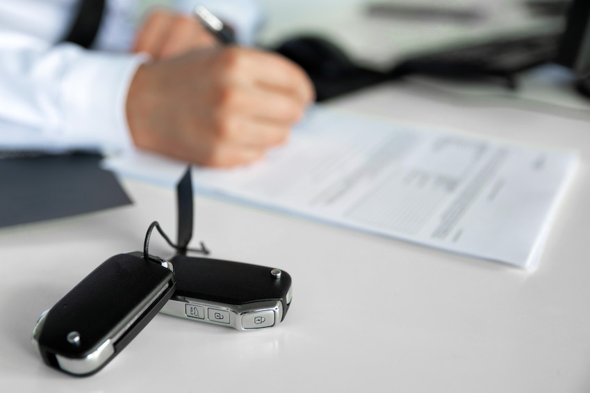 Client purchasing a new car. Car seller making a deal in dealer showroom